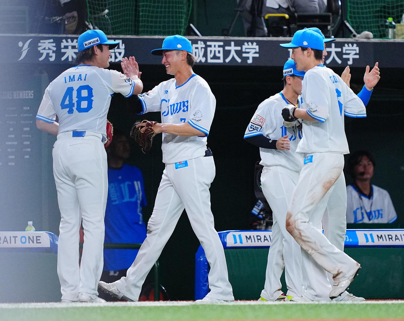西武対ロッテ　8回表を終えこの回好守を見せた西武金子（中央）は今井（左）と笑顔でタッチを交わす。右は源田（撮影・垰建太）