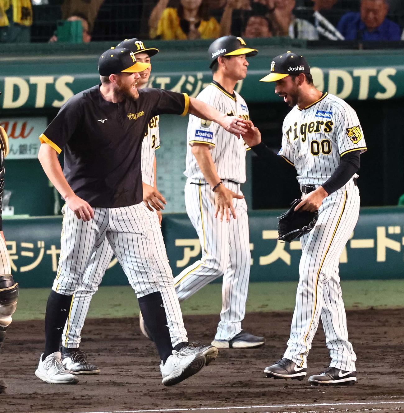 阪神対ヤクルト　8勝目を挙げたビーズリー（左）は最後を締めたゲラとハイタッチする（撮影・上田博志）