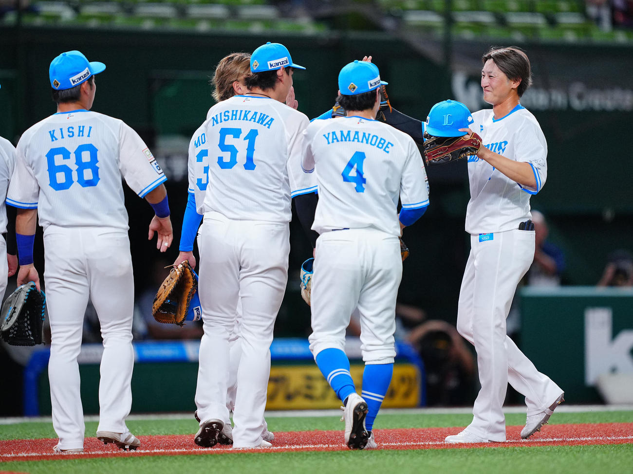 西武対ロッテ　試合前シートノックを終えチームメートたちと笑顔でタッチを交わす西武金子（右）（撮影・垰建太）