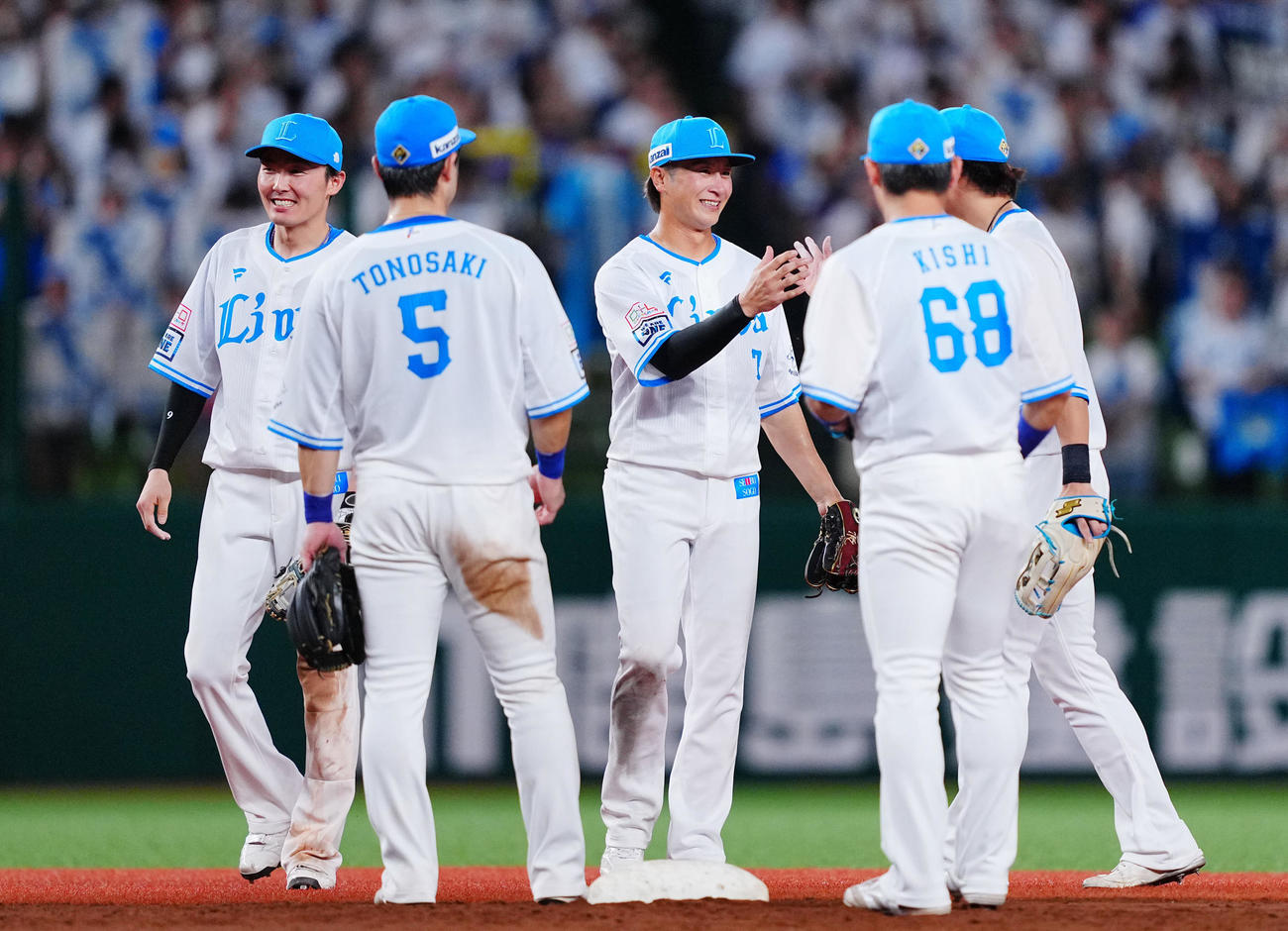 西武対ロッテ　ロッテに勝利し笑顔でナインとタッチを交わす西武金子（中央）（撮影・垰建太）