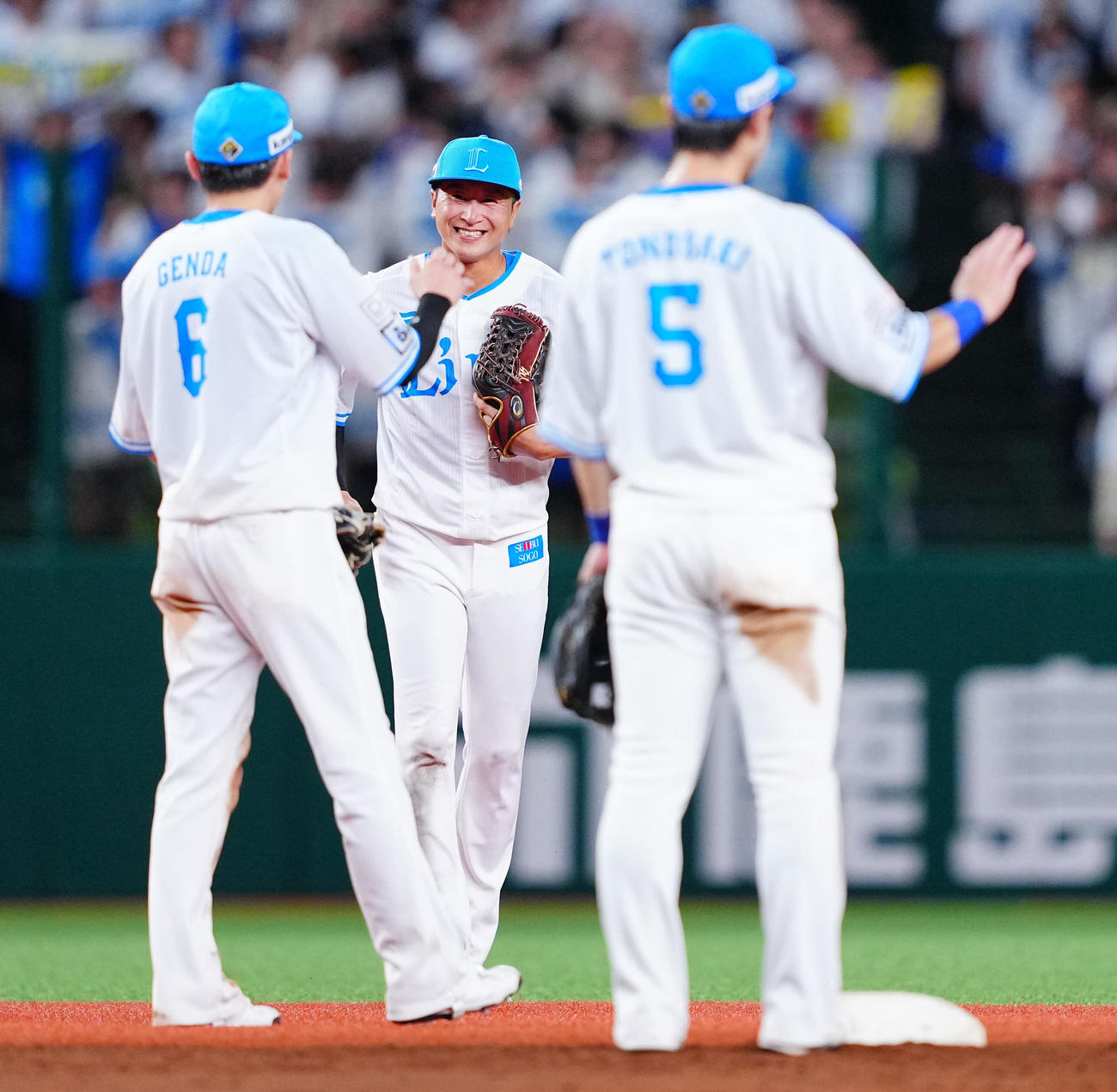 西武対ロッテ　ロッテに勝利し笑顔でナインとタッチを交わす西武金子（中央）（撮影・垰建太）