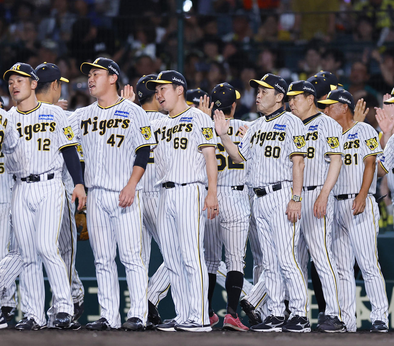 阪神対ヤクルト　ヤクルトに勝利し、ナインを出迎える左から阪神坂本、桐敷、石井、岡田監督（撮影・藤尾明華）