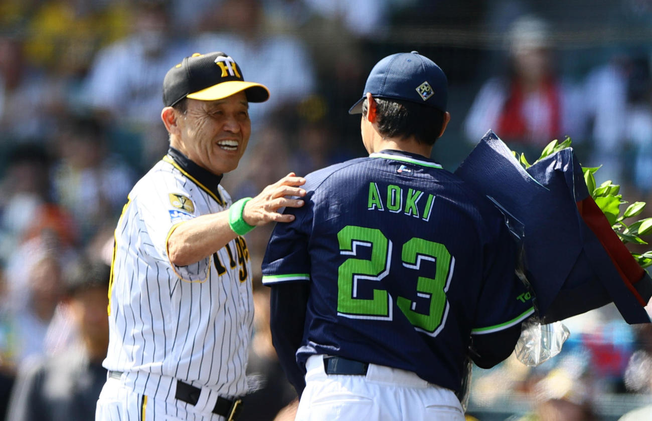 阪神対ヤクルト　試合前、引退を発表したヤクルト青木（手前）にねぎらいの花束を贈る阪神岡田監督（撮影・上山淳一）