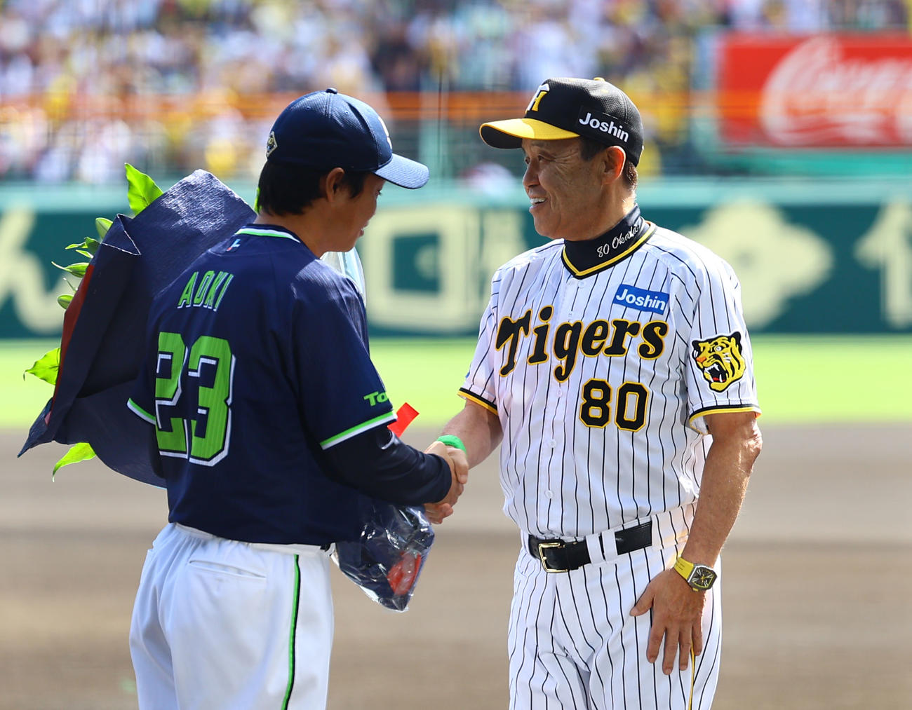 阪神対ヤクルト　ヤクルト青木（左）に花束を贈り、握手を交わす阪神岡田監督（撮影・藤尾明華）