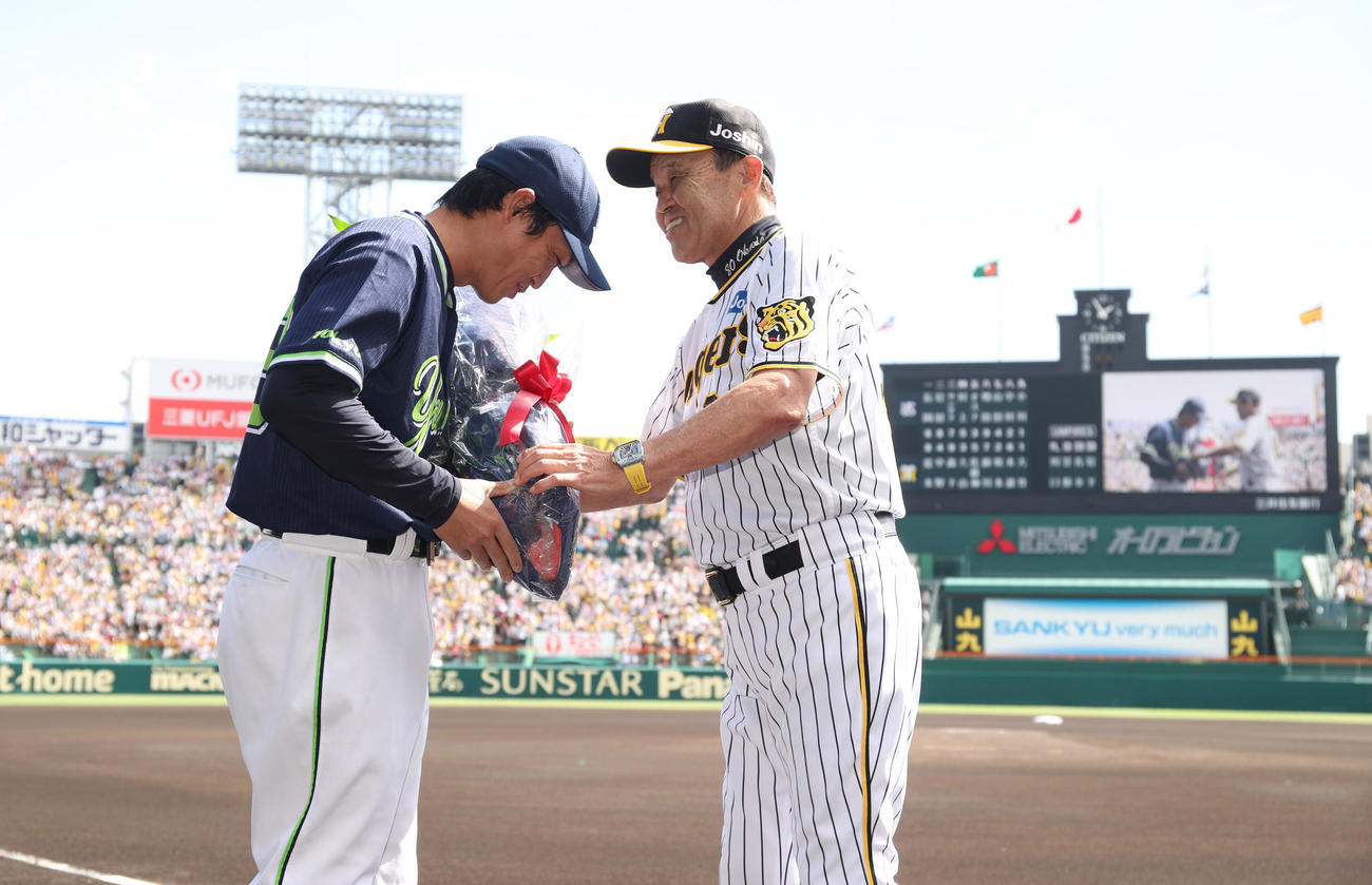 阪神対ヤクルト　ヤクルト青木（左）は阪神岡田監督からねぎらいの花束を受け取る（代表撮影）