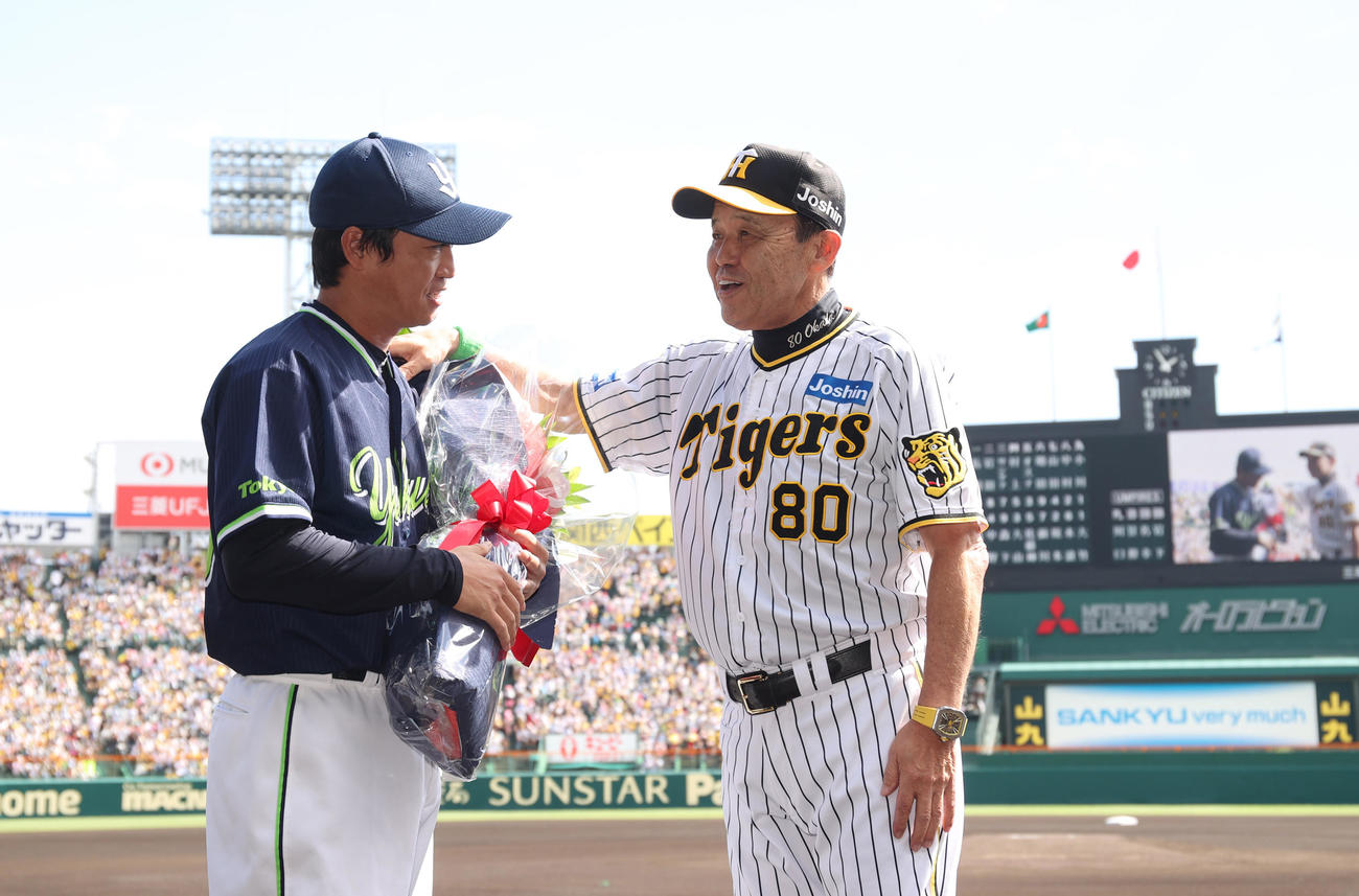阪神対ヤクルト　試合前、引退を発表したヤクルト青木（左）にねぎらいの花束を贈る阪神岡田監督（代表撮影）