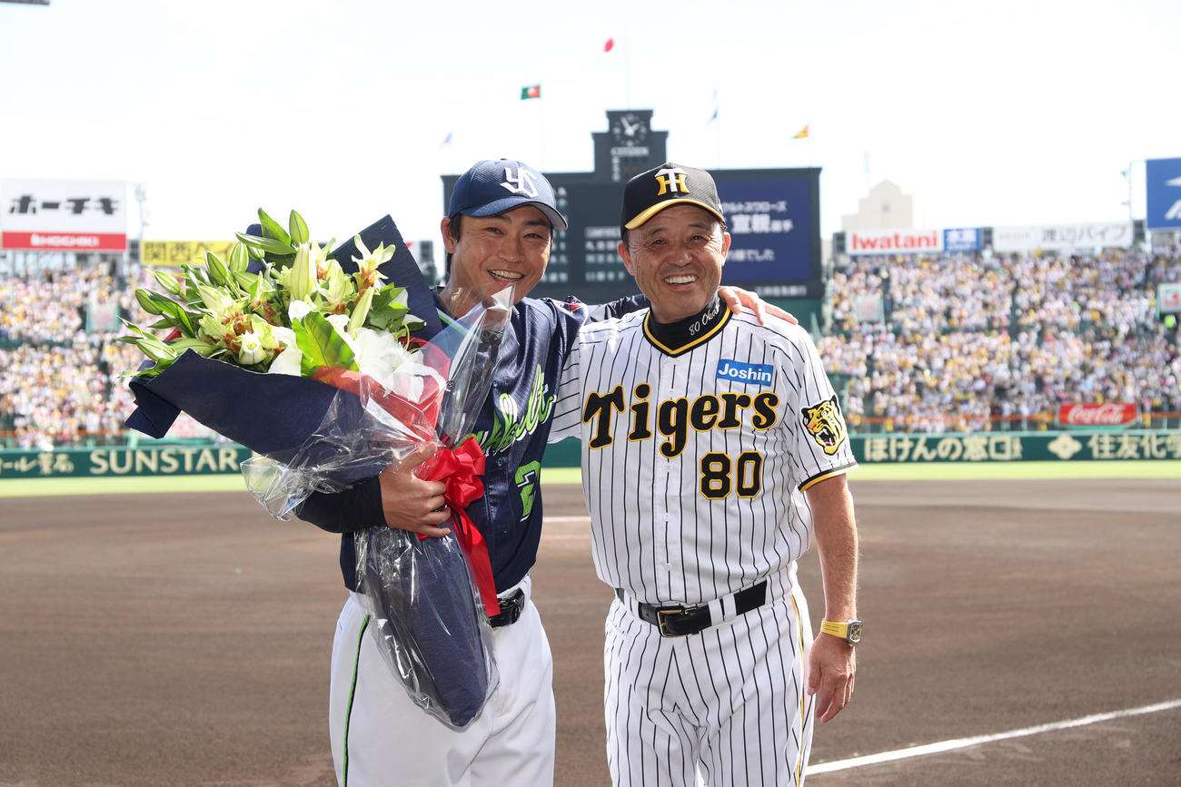 阪神対ヤクルト　ヤクルト青木（左）は阪神岡田監督からねぎらいの花束を贈られ笑顔で記念撮影する（代表撮影）