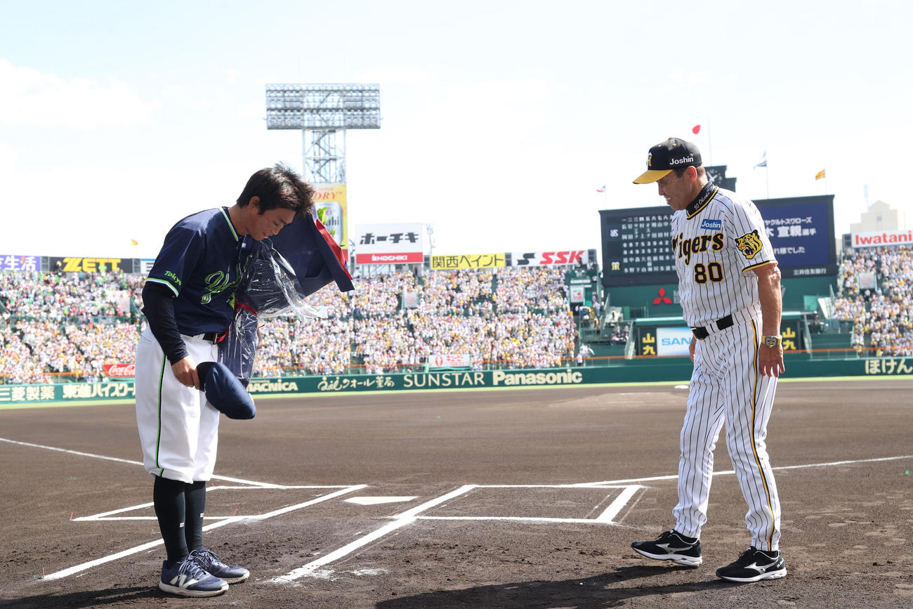 阪神対ヤクルト　試合前、引退を発表したヤクルト青木（左）は阪神岡田監督から花束を贈られ感謝する（代表撮影）