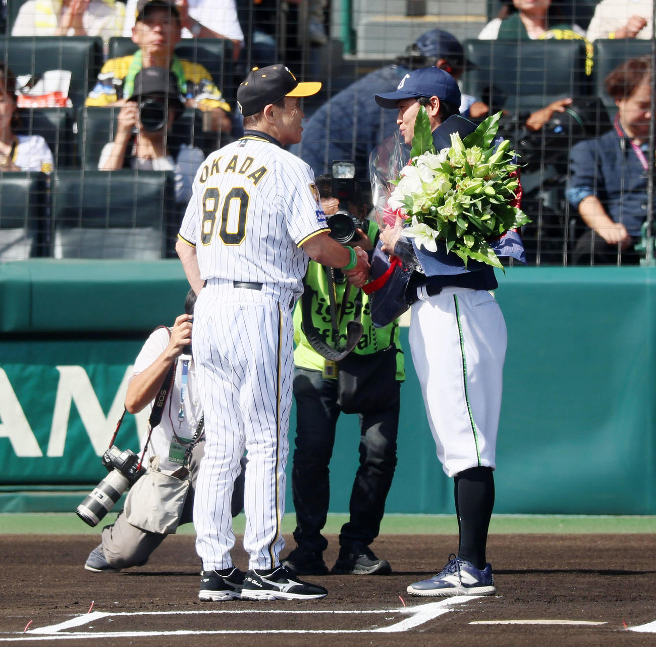 阪神対ヤクルト　引退するヤクルト青木（右）に記念の花束を手渡した阪神岡田監督（撮影・加藤哉）