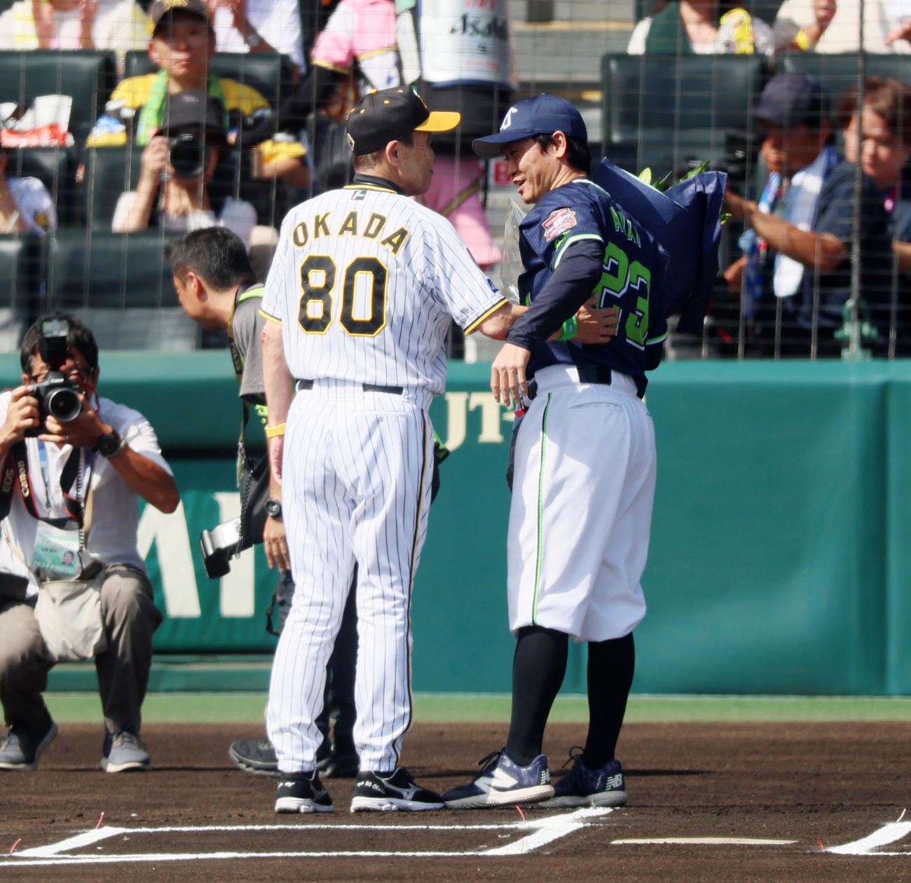 阪神対ヤクルト　引退するヤクルト青木（右）に記念の花束を手渡した阪神岡田監督（撮影・加藤哉）