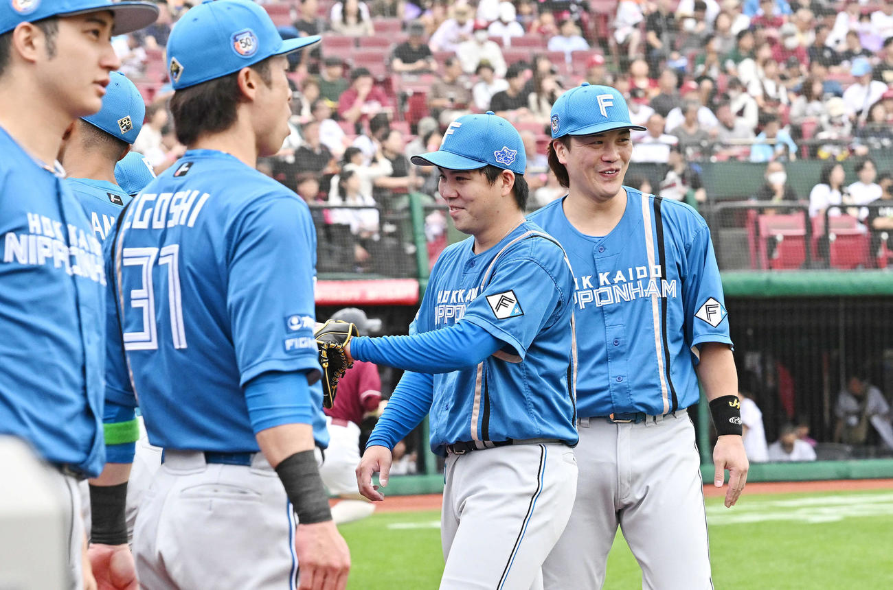 楽天対日本ハム　2回裏を投げ終えた日本ハム先発の金村（右から2人目）はチームメートとタッチをかわす（撮影・滝沢徹郎）