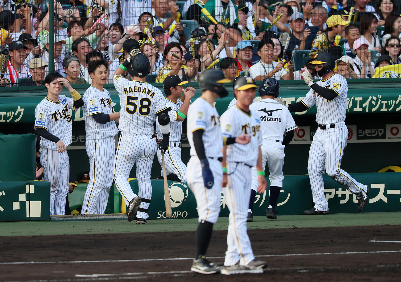 阪神対ヤクルト　6回裏阪神無死満塁、大竹（左から2人目））は中犠飛を打ち上げた前川（左から3人目）と生還した三塁走者森下（右）を笑顔で出迎える（撮影・加藤哉）