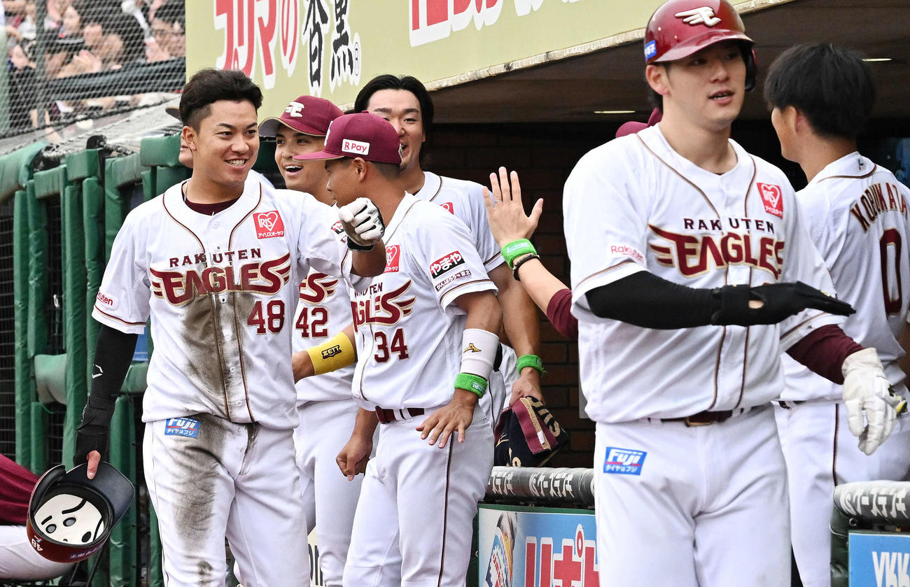楽天対日本ハム　7回裏楽天無死二、三塁、村林の2点適時二塁打で生還した渡辺佳（左）はチームメートとタッチをかわす（撮影・滝沢徹郎）