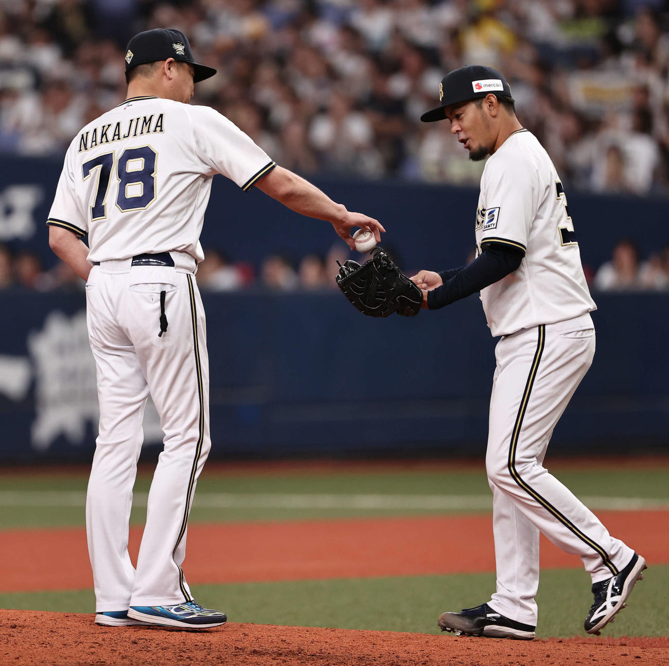 オリックス対ソフトバンク　8回表ソフトバンク2死二塁の場面で登板したオリックス比嘉（右）はマウンドで中嶋監督からボールを受け取る（撮影・西尾就之）