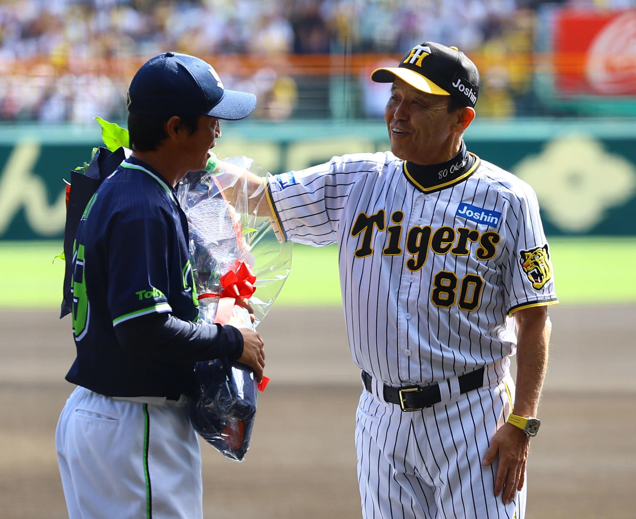 阪神対ヤクルト　ヤクルト青木（左）に花束を贈り、労う阪神岡田監督（撮影・藤尾明華）