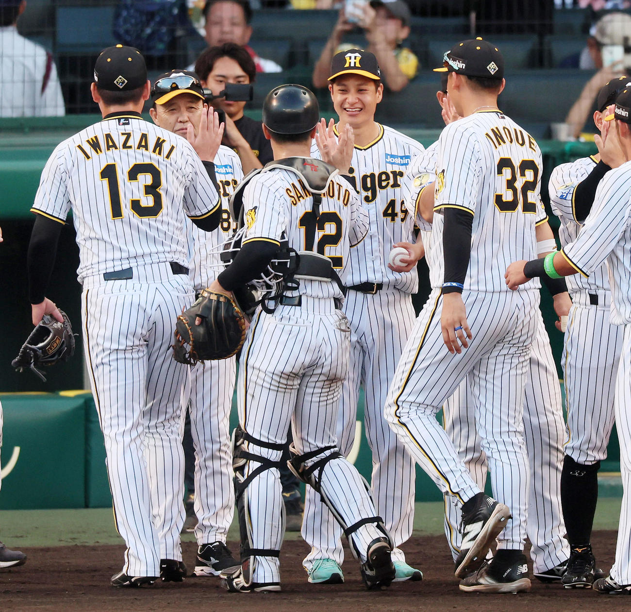 阪神対ヤクルト　ヤクルトに勝利し笑顔でナインとタッチする大竹。左から2人目は岡田監督（撮影・加藤哉）