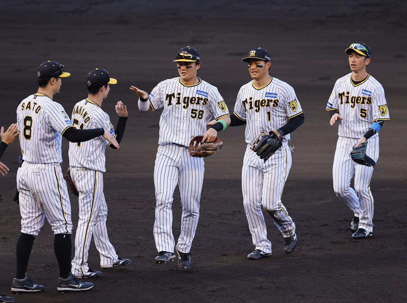 阪神対ヤクルト　勝利を飾りタッチを交わす右から阪神近本、森下、前川ら阪神ナイン（撮影・藤尾明華）