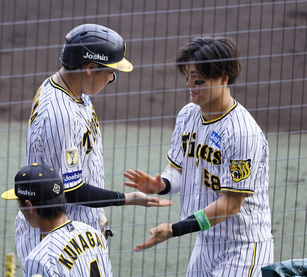 阪神対ヤクルト　6回裏阪神2死満塁、相手暴投で生還した大山（左）とタッチを交わす前川（撮影・藤尾明華）
