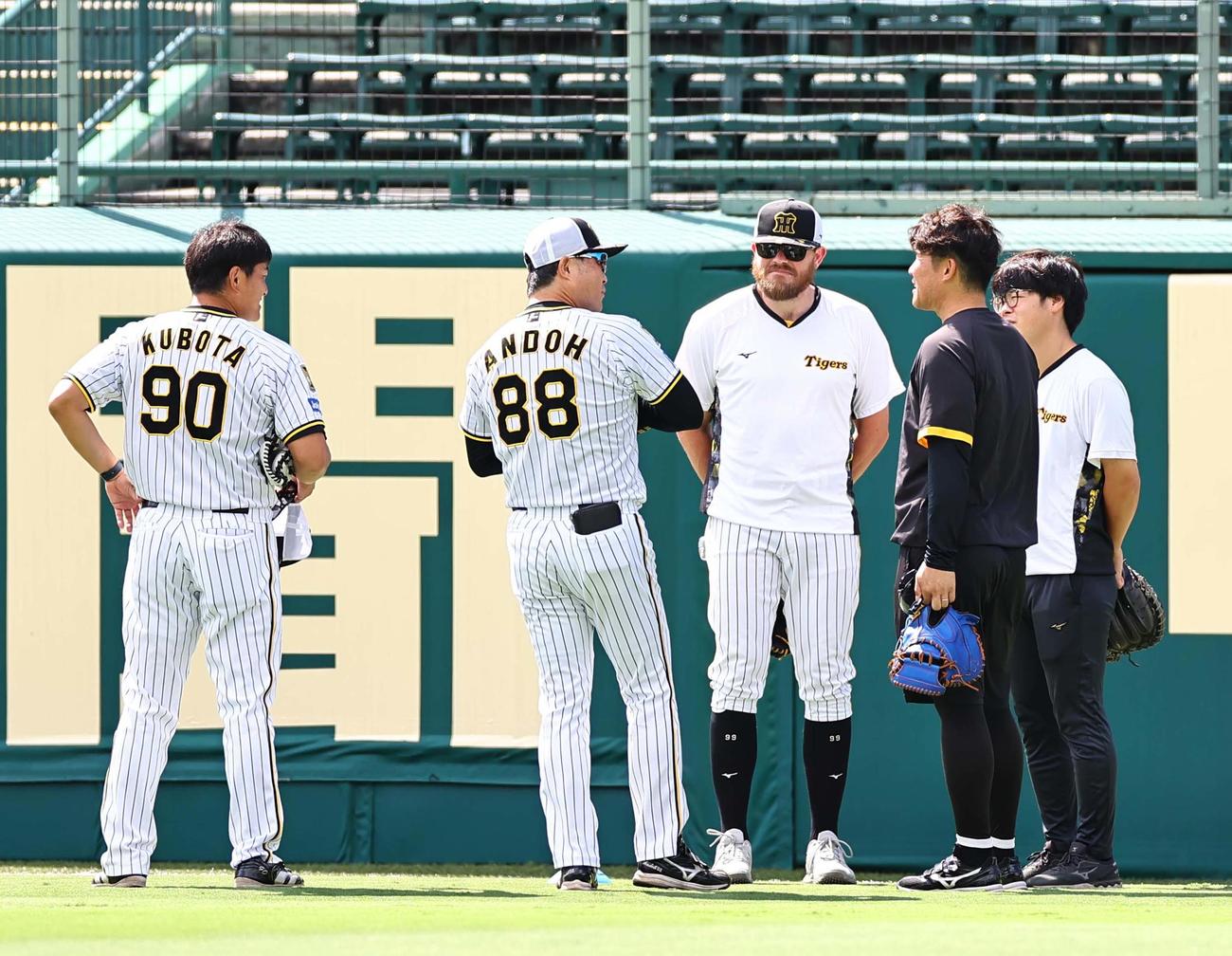16日、ヤクルト戦前練習でビーズリー（中央）は久保田（左）、安藤両コーチと話し合う