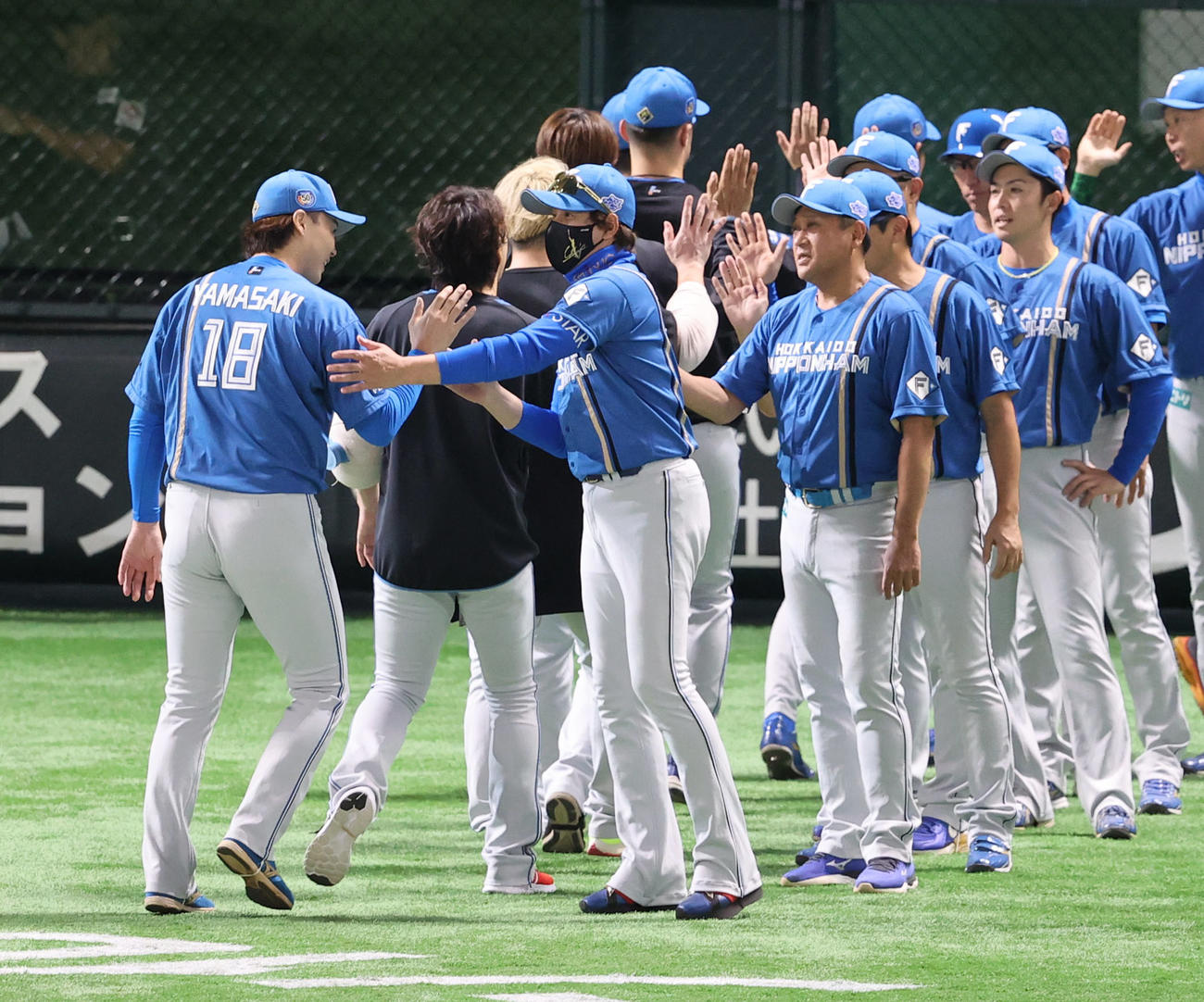 ソフトバンク対日本ハム　勝利投手となった山■（■は崎の大が立の下の横棒なし）とハイタッチする新庄監督（撮影・梅根麻紀）