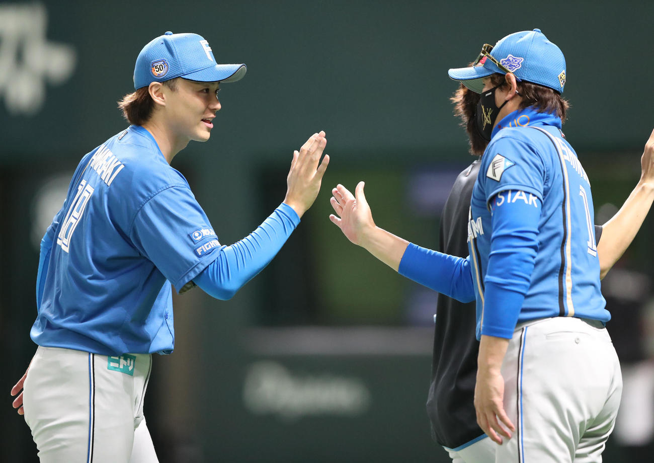 ソフトバンク対日本ハム　ソフトバンクに勝利しタッチをかわす山崎（左）と新庄監督（撮影・鬼束羽瑠菜）