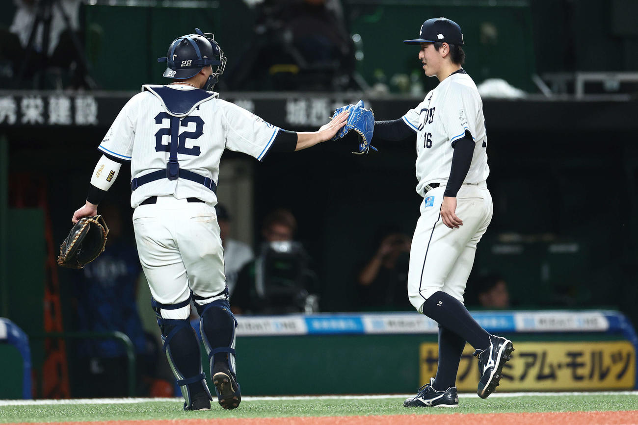 西武対オリックス　8回表を抑え、タッチを交わす古賀（左）と隅田（撮影・河田真司）