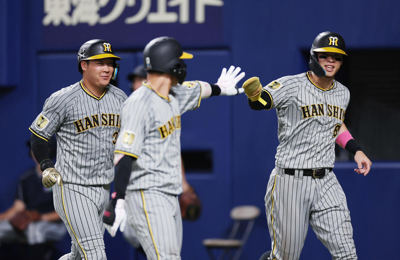 中日対阪神　9回表阪神2死二、三塁、坂本の2点適時打で生還し、笑顔を見せる大山（左）と佐藤輝（撮影・前田充）