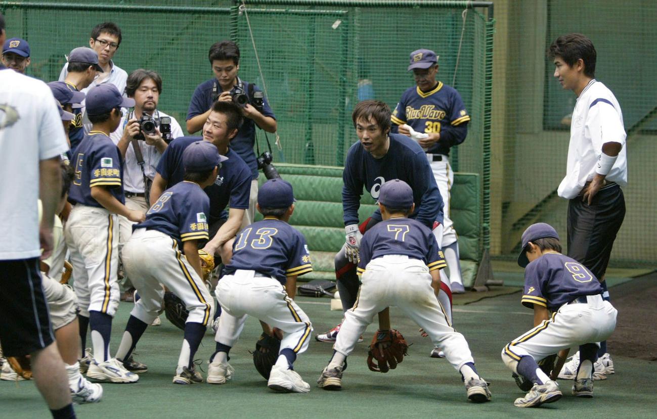 少年野球の選手たちに室内練習場で指導を行った塩崎真（中央）らオリックスナイン。右端は三輪隆選手会長（2004年9月19日撮影）