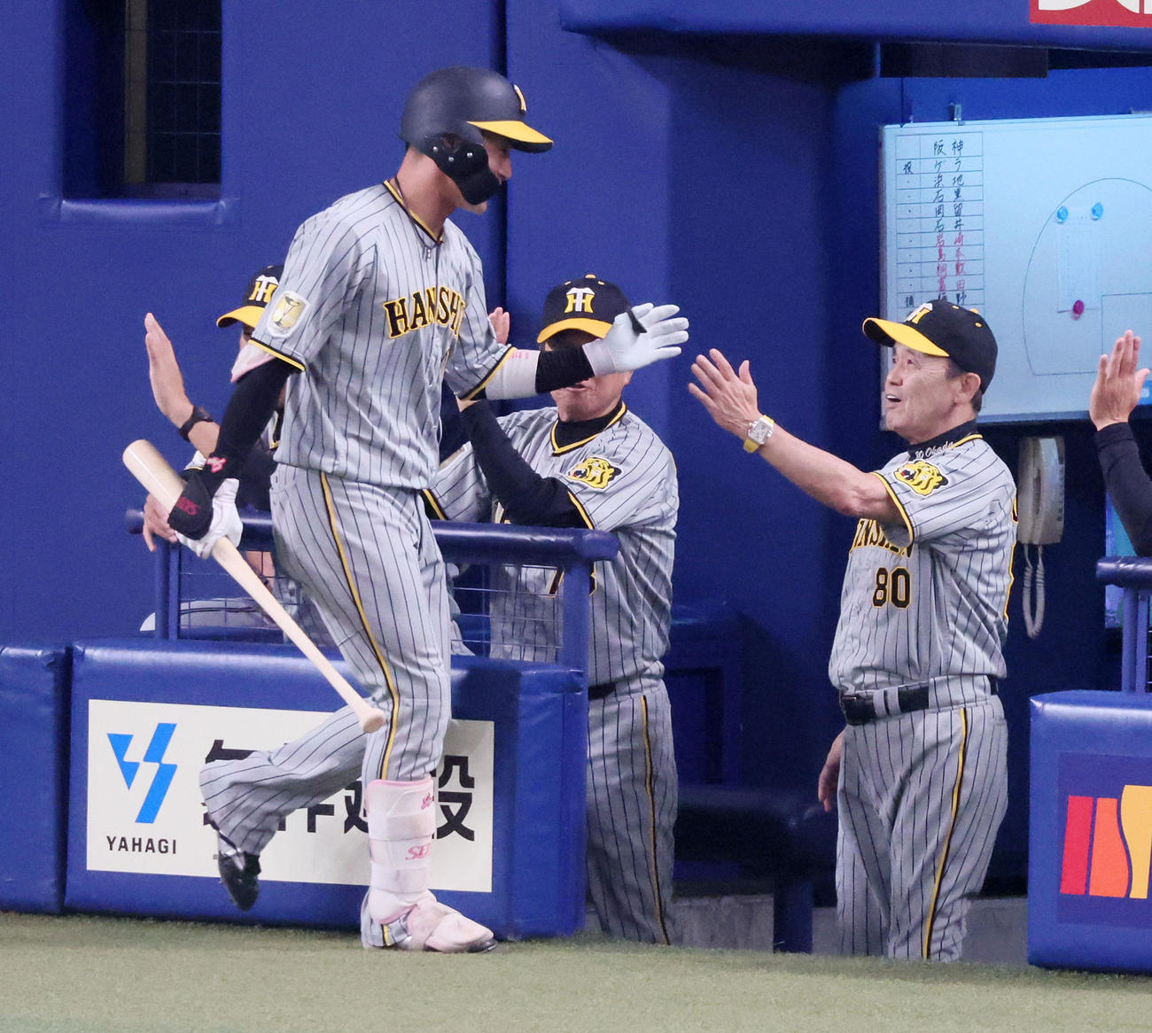 中日対阪神　4回表阪神1死一、三塁、二ゴロを打ち得点を挙げた木浪（左）をベンチで迎える岡田監督（撮影・加藤哉）