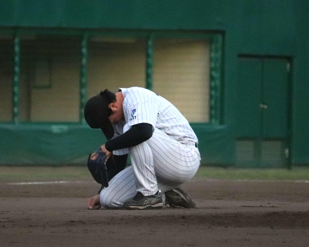 NTT西日本との代表決定戦　4番手で登板し12回1死満塁で悪送球の間に走者生還を許し、マウンドの横でうずくまる、三菱重工Westの竹田（撮影・中島麗）
