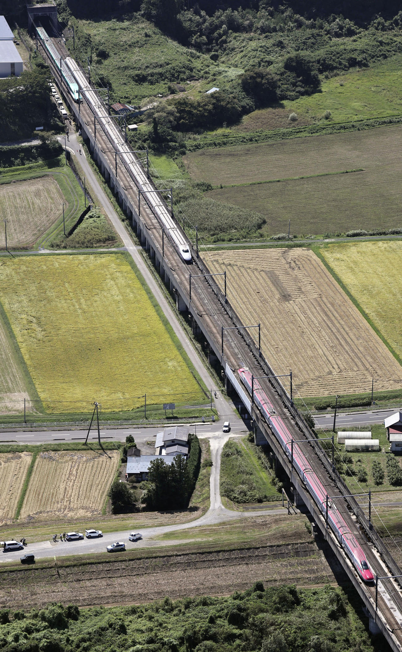 古川―仙台間で走行中に車両の連結が外れ、分離して停車した東北新幹線の「はやぶさ・こまち6号」。左上がはやぶさ、下がこまち＝19日午前11時7分、宮城県大崎市（共同通信社ヘリから＝共同）