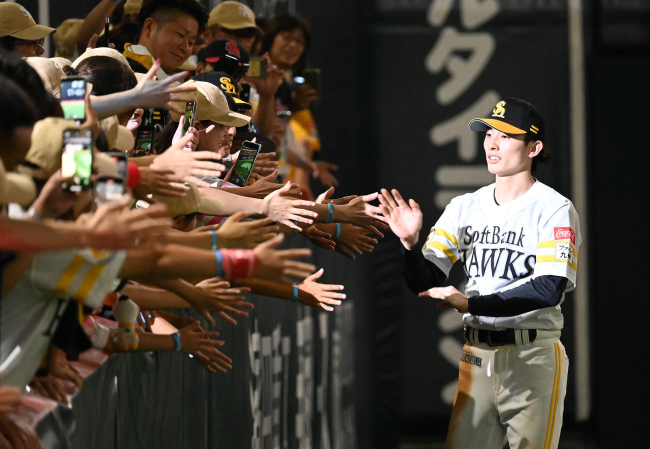 ソフトバンク対オリックス　ファンとタッチを交わす周東（右）（撮影・林敢治）