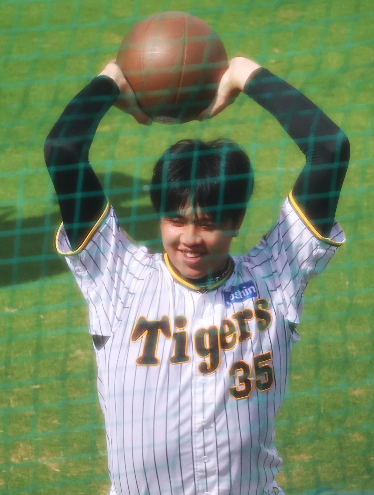 鳴尾浜でメディシンボールを手に笑顔の阪神・才木（撮影・塚本光）