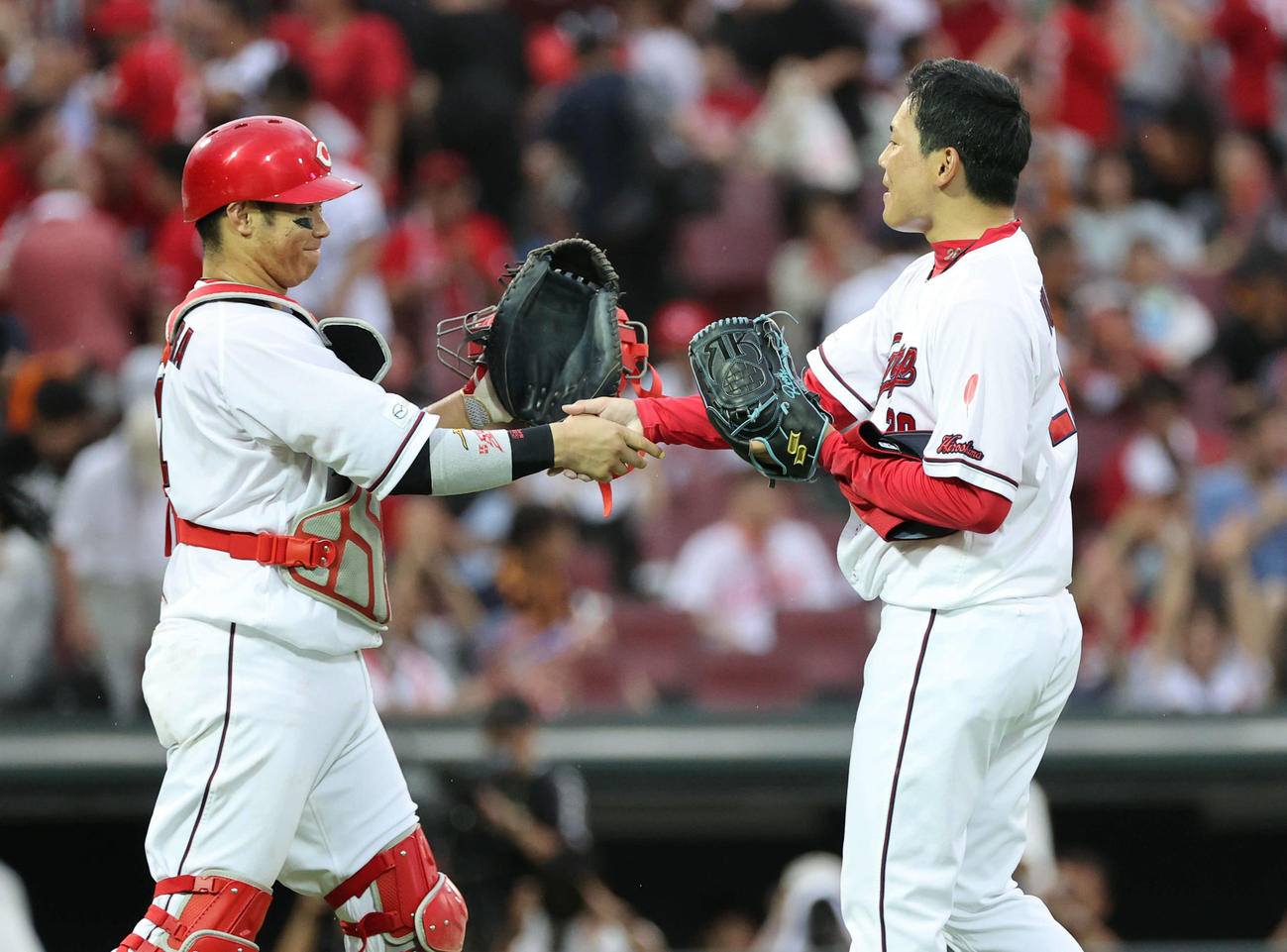 広島対巨人　9回表巨人、最後を締めた栗林（右）は坂倉と握手（撮影・加藤孝規）
