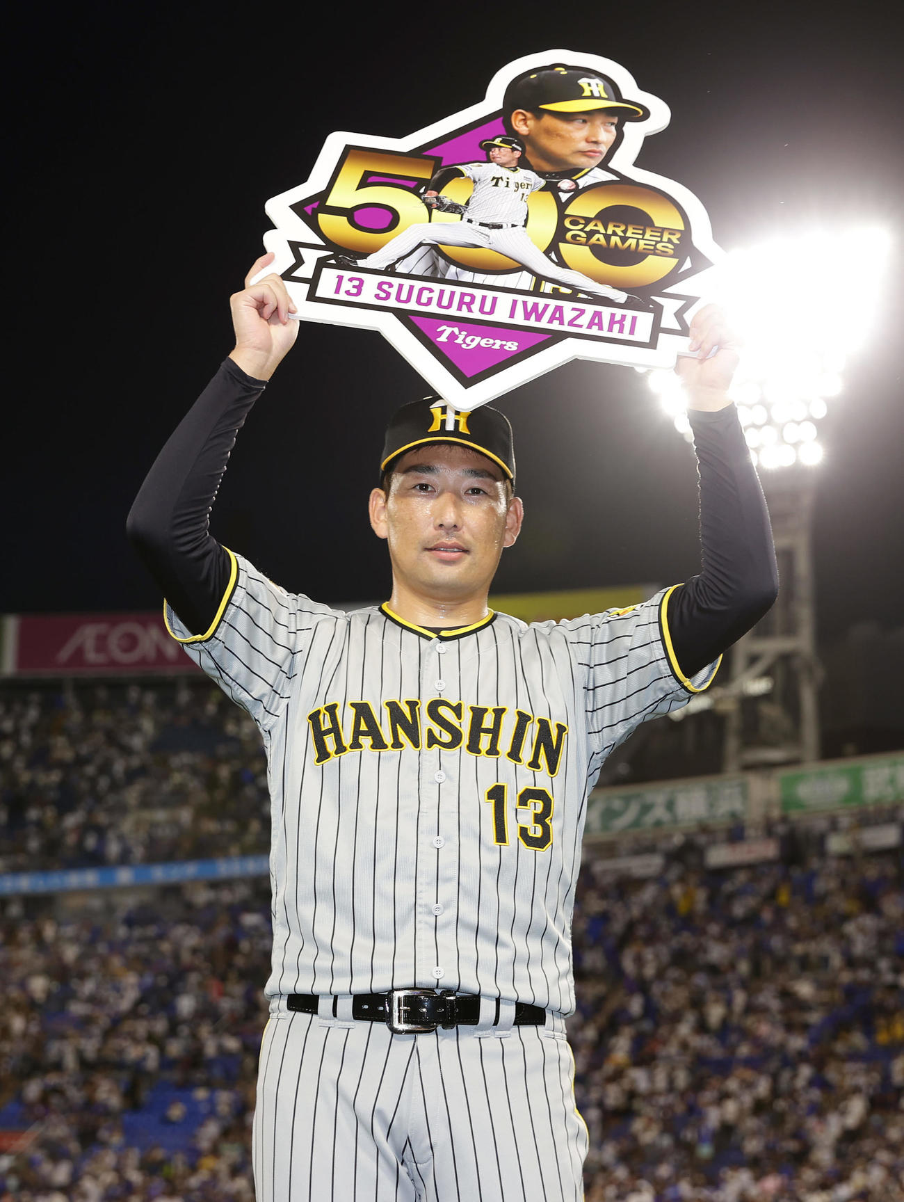 DeNA対阪神　通算500試合登板を達成し、記念ボードを掲げる阪神岩崎（撮影・前田充）