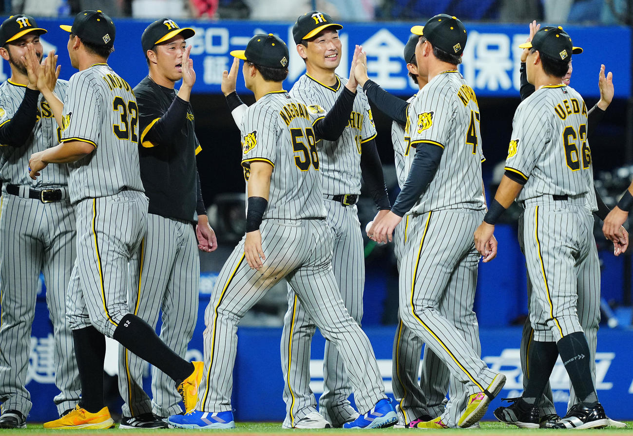 DeNA対阪神　DeNAに勝ち勝利投手の阪神岩崎（中央）は勝利球を手に笑顔でナインとタッチを交わす（撮影・垰建太）