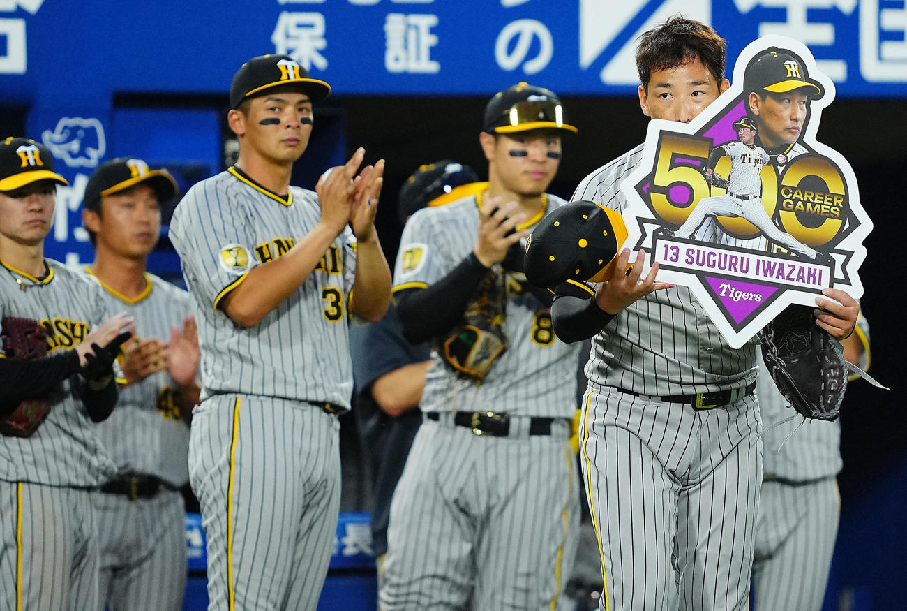 DeNA対阪神　9回裏を投げ終え通算500試合の登板を達成し記念ボードを手にする阪神岩崎（撮影・垰建太）