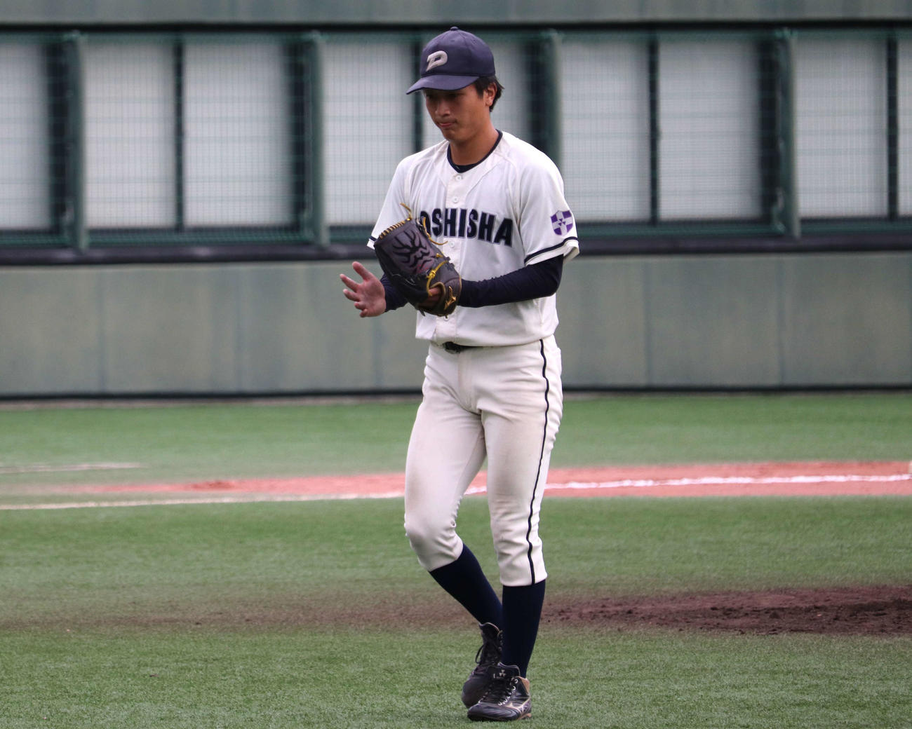 関大との1回戦　8回の1イニングをゼロに抑え、グラブをポンとたたきベンチに帰る同大・清川（撮影・中島麗）