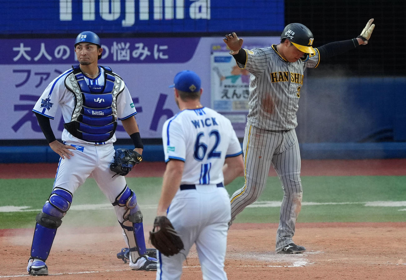 DeNA対阪神　8回表阪神無死満塁、牧秀悟の暴投で生還する大山（右）（撮影・横山健太）