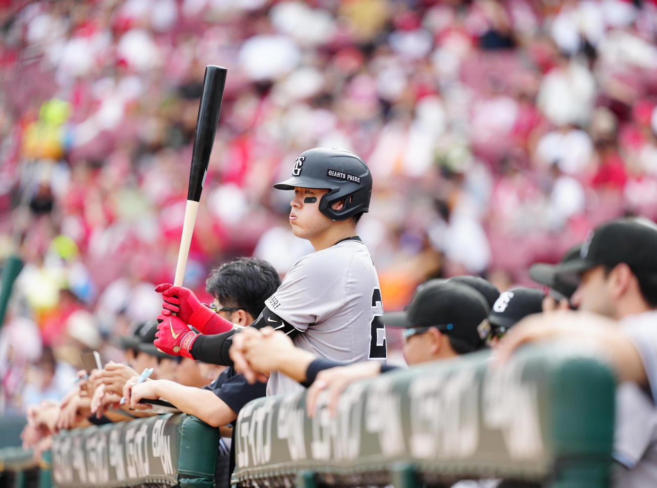 広島対巨人　3回表、ベンチでバットを手にする巨人岡本和（撮影・江口和貴）