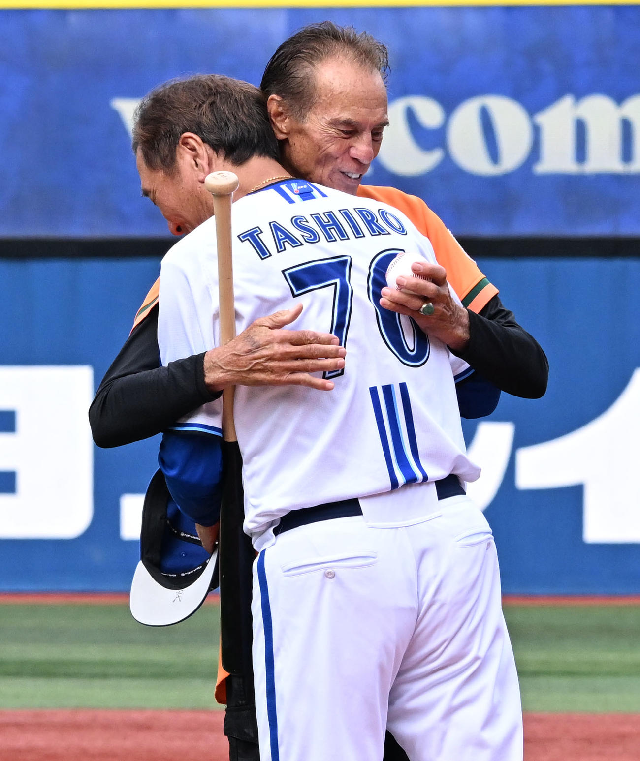 DeNA対ヤクルト　セレモニアルピッチを終え、打者を務めたDeNA田代コーチ（手前）とハグするシピンさん（撮影・千葉一成）