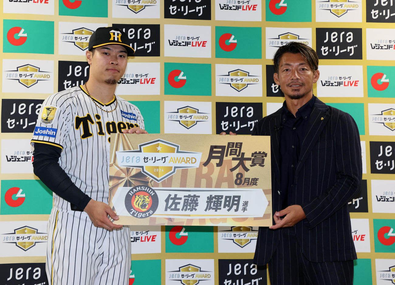 プレゼンターの鳥谷氏（右）からJERA8月度月間大賞のボードを受けとる佐藤輝（撮影・加藤哉）