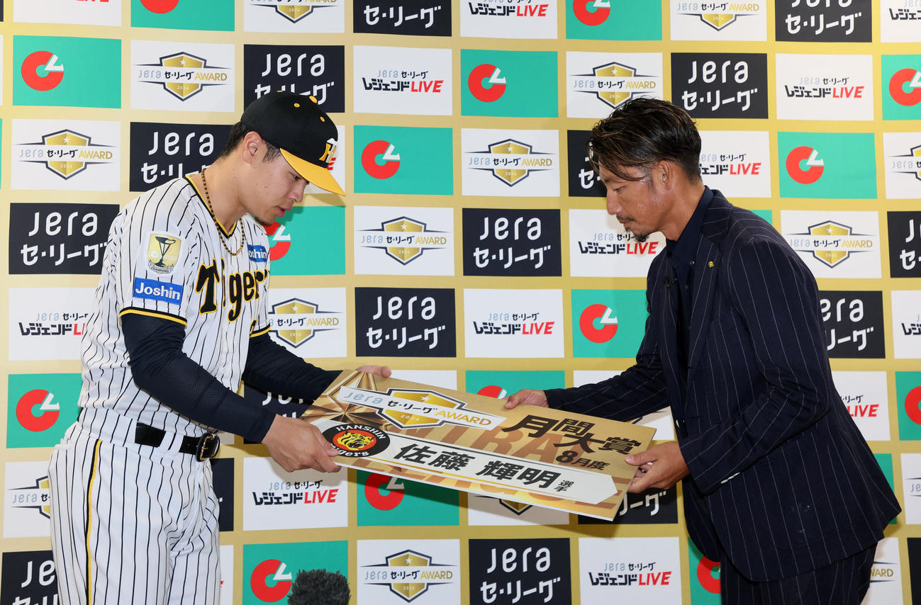 プレゼンターの鳥谷氏（右）からJERA8月度月間大賞のボードを受けとる佐藤輝（撮影・加藤哉）