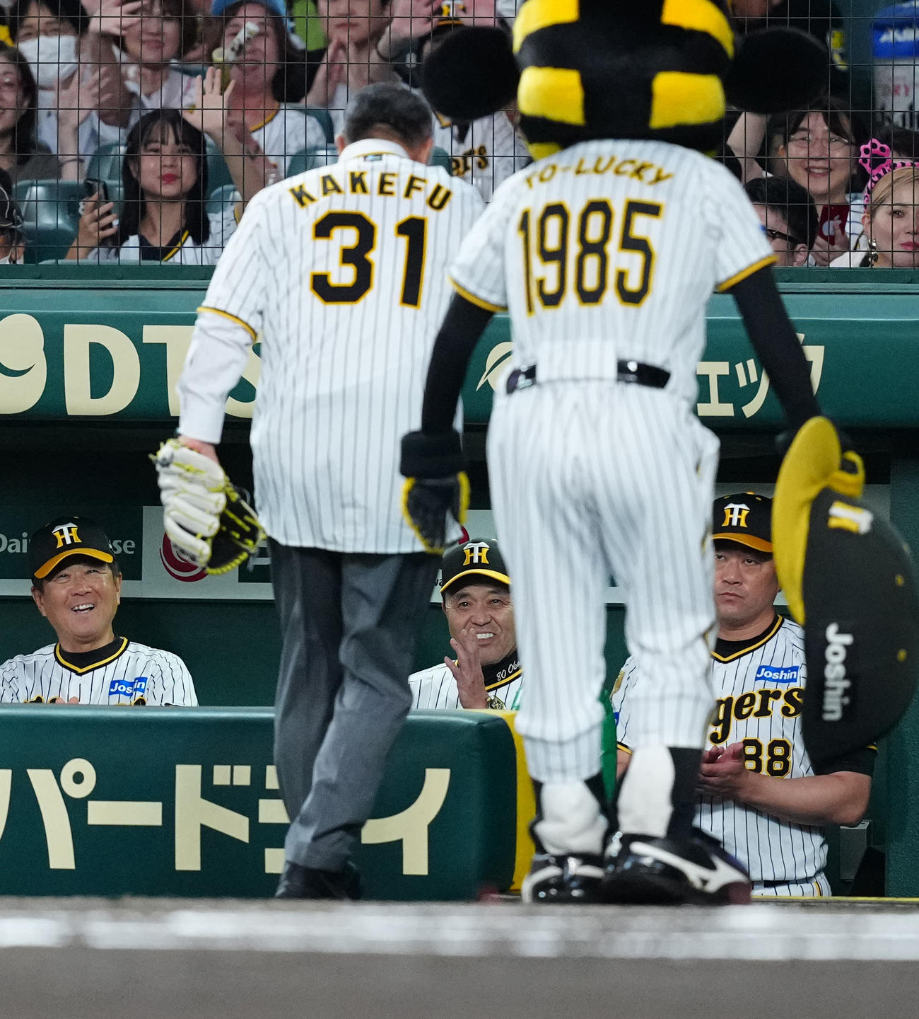 阪神対巨人　試合前、始球式に臨んだ掛布氏（手前左）に拍手する岡田監督（中央）（撮影・江口和貴）