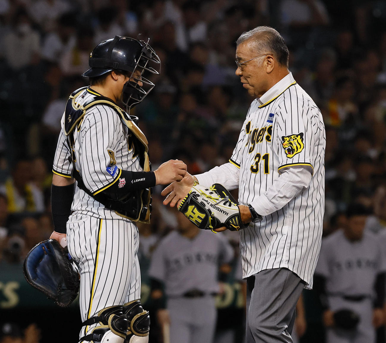 阪神対巨人　始球式を務め梅野隆太郎（左）と握手を交わす阪神OBの掛布雅之氏（撮影・藤尾明華）