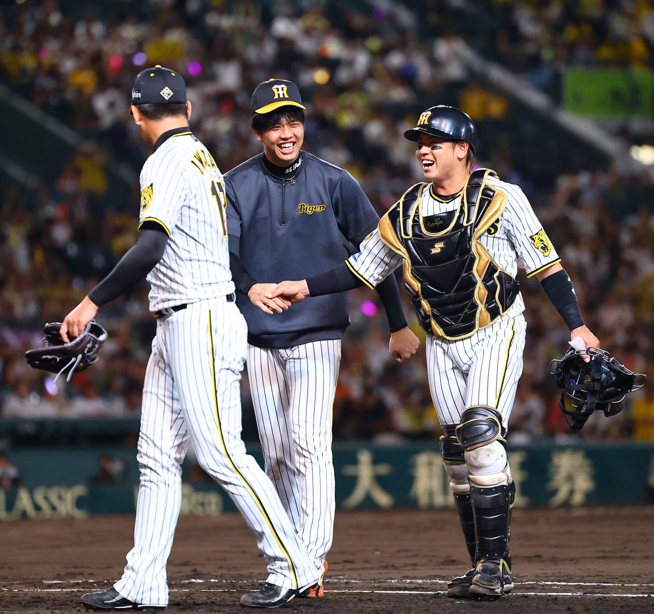 阪神対巨人　巨人に勝利し、握手を交わすを交わす阪神才木（中央）と梅野（撮影・藤尾明華）