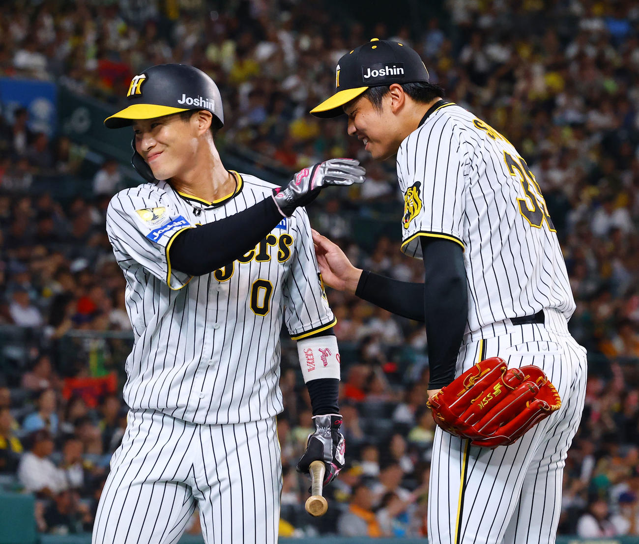 阪神対巨人　3回裏阪神2死一、三塁、中野の先制適時打で生還し、才木（右）と笑顔を見せる木浪（撮影・藤尾明華）