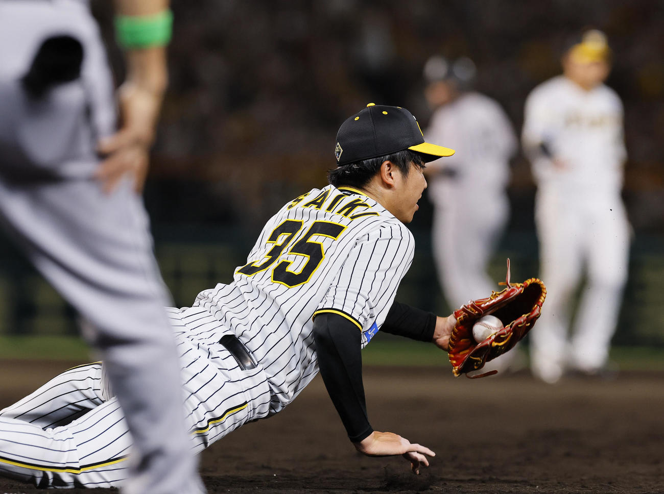 阪神対巨人　7回表巨人1死一塁、丸の一ゴロで倒れ込みながらベースカバーに入る才木（撮影・藤尾明華）