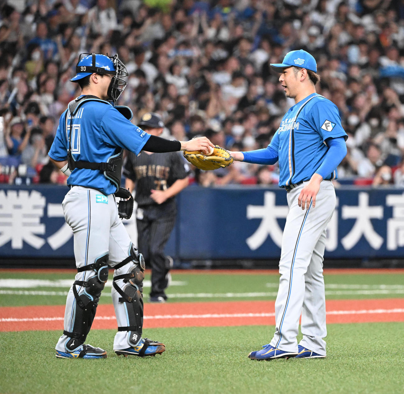 オリックス対日本ハム　2失点で完投勝利し捕手郡司（左）とタッチ日本ハム加藤（撮影・和賀正仁）