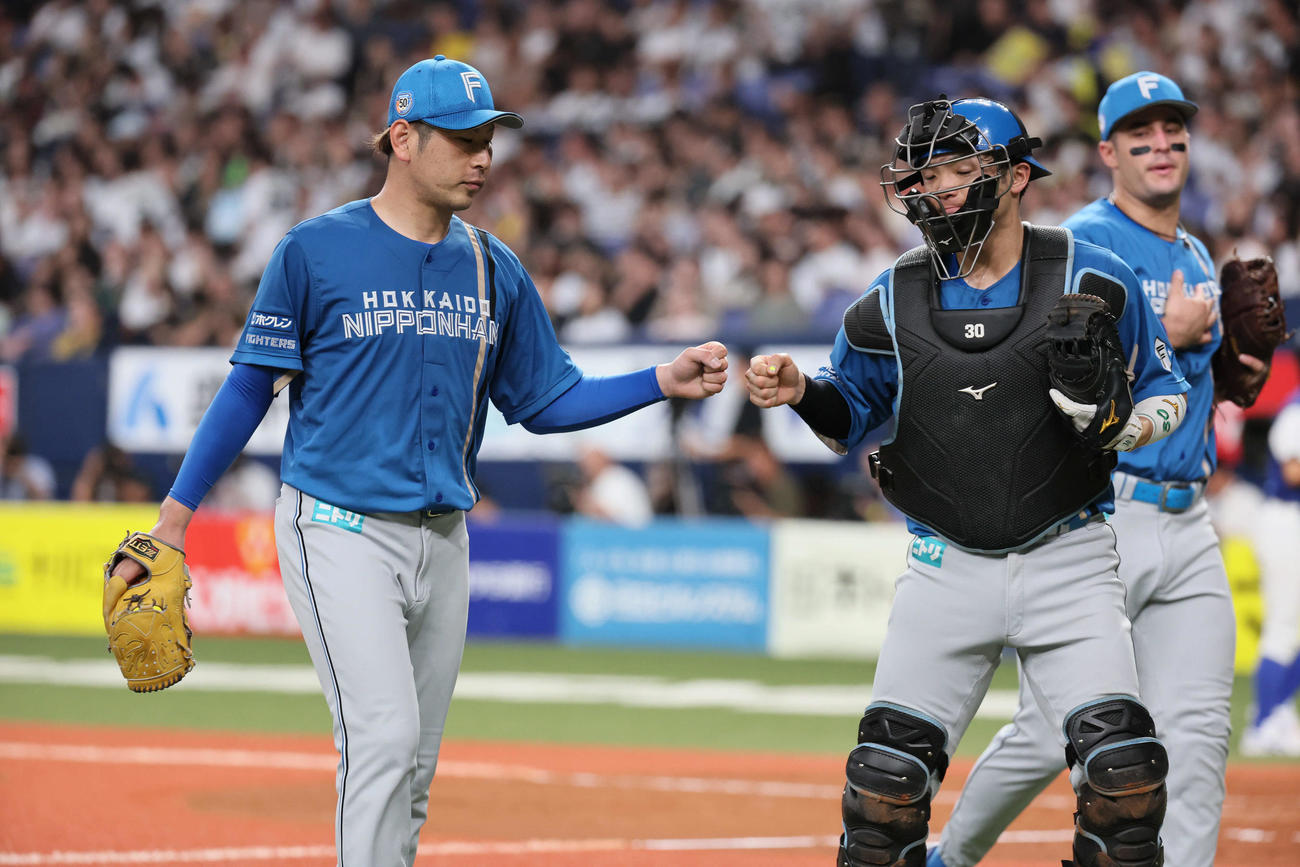 オリックス対日本ハム　5回を抑えた日本ハム先発の加藤（左）は郡司とグータッチ（撮影・宮崎幸一）